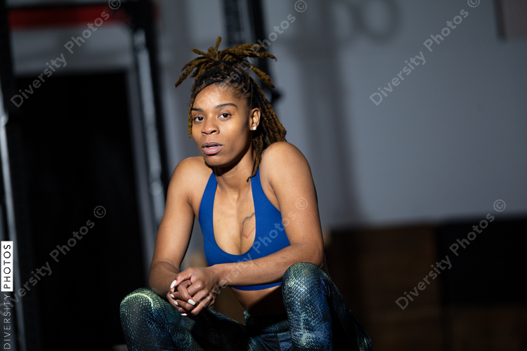 African American woman resting during workout at gym, sitting, health and wellness