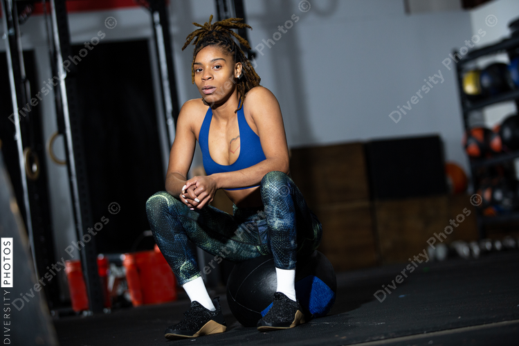 African American woman resting during workout at gym, sitting, health and wellness