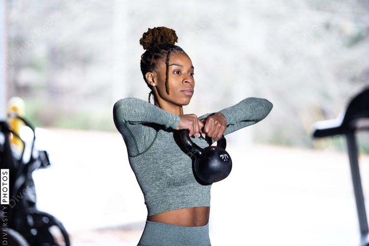 Black woman does fitness workout, kettlebell upright row