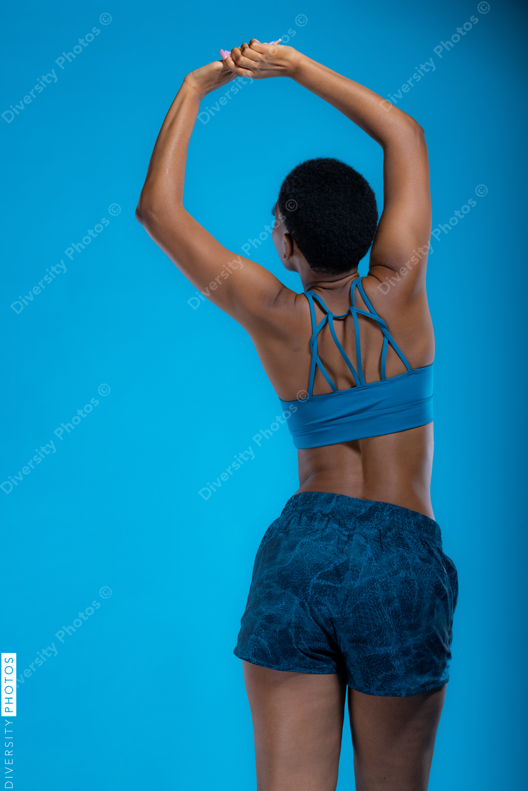 Rear view of Black woman doing stretches before wellness workout