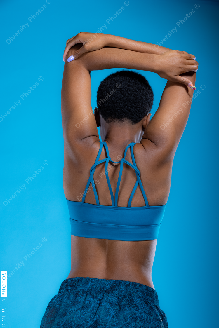 Rear view of Black woman doing stretches before wellness workout