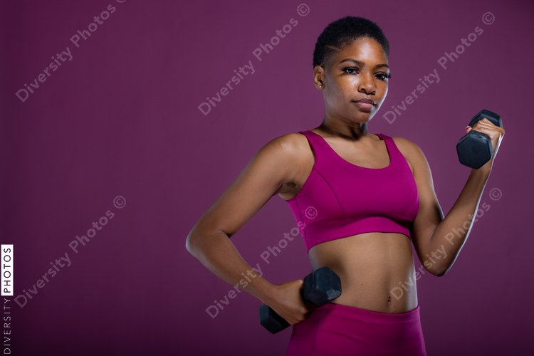 Black woman doing workout with dumbbells 