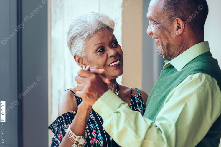 Smiling senior couple dancing at home