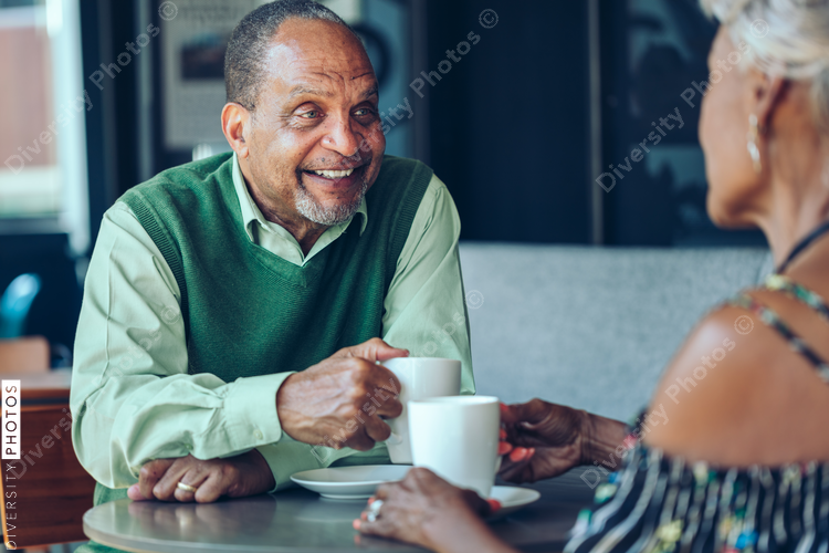 Senior couple having coffee at cafe table