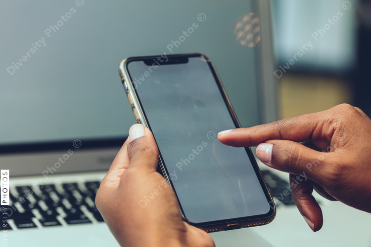 Close up of businesswoman's hands using cell phone in office