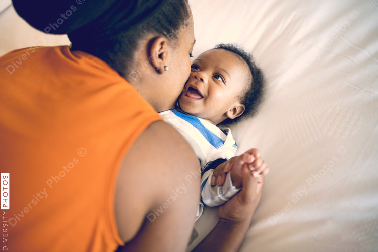 Mother playing with her son on bed at home