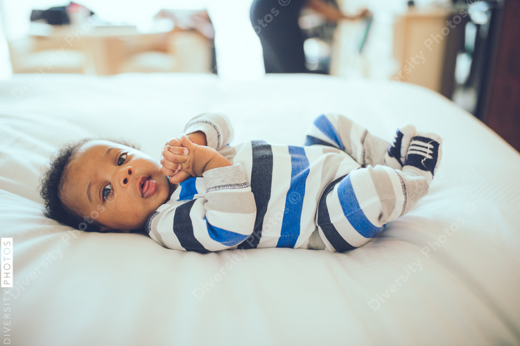 Portrait of baby boy lying on bed at home