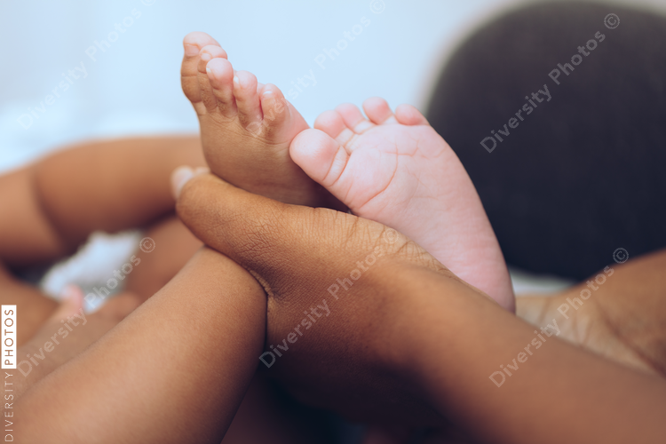 Close up of mother's hand holding baby's feet