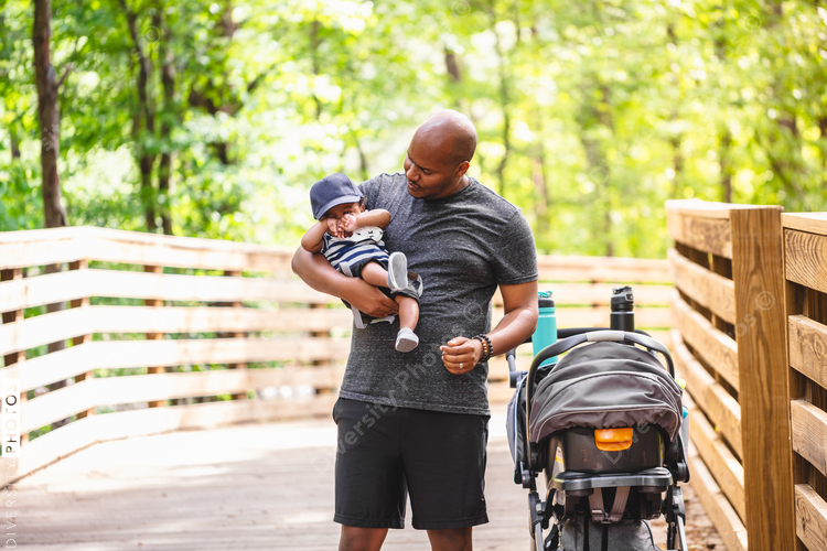 Father carries baby son on outdoor trail