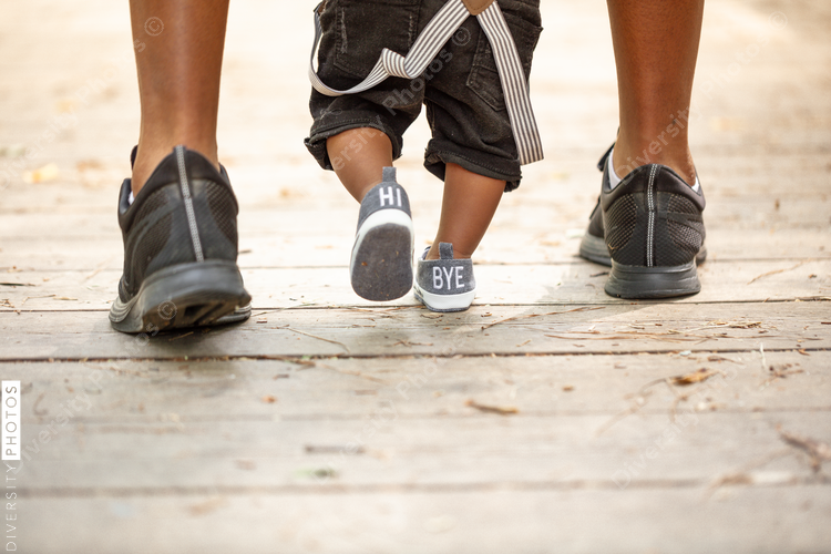black father helping son walk