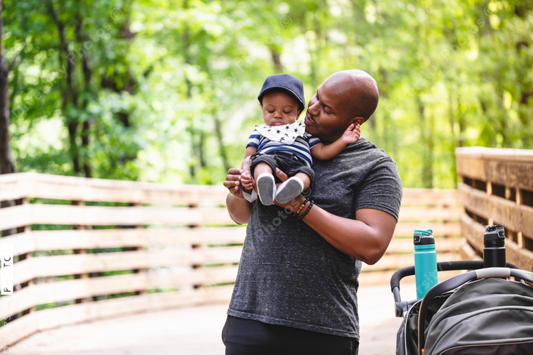 Father holds baby son on outdoor trail