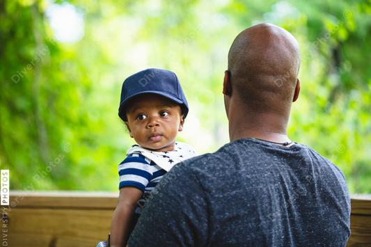 Baby son looks over father's shoulder