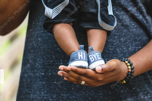 Baby boy stands on father's hand