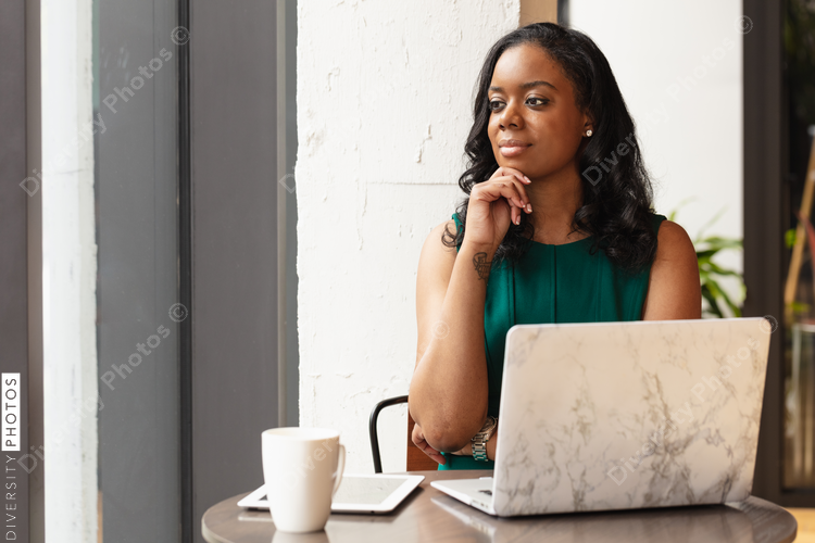 Businesswoman rests chin on hand in front of laptop