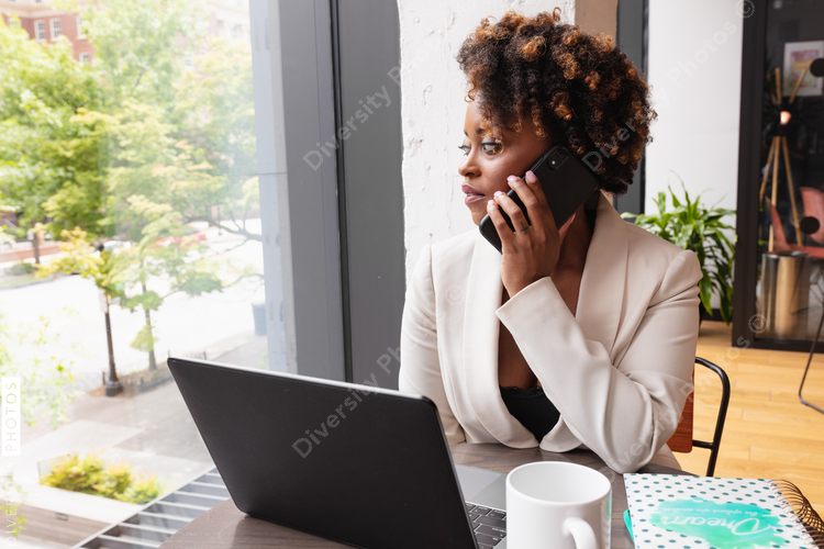Businesswoman talks on phone while looking out window