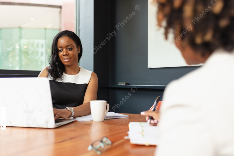 Businesswoman types on laptop during meeting