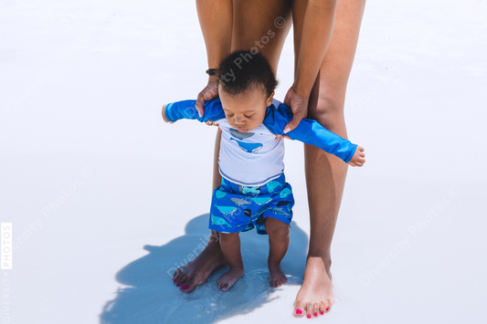 Black mother helping son to walk
