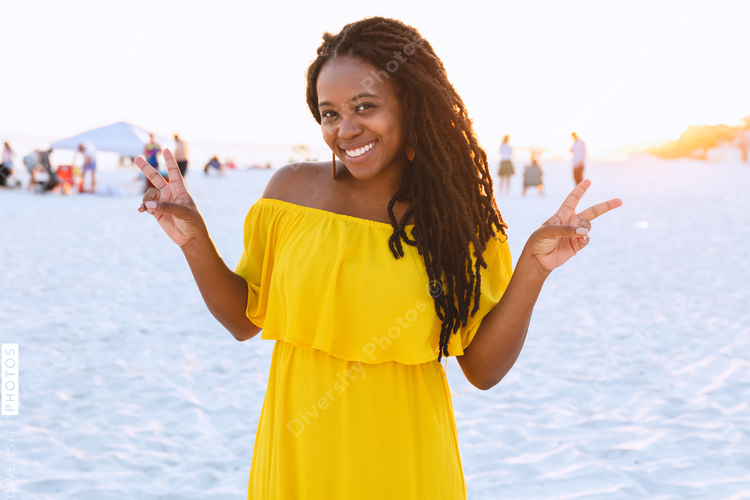 Black woman in pretty sun dress on the beach