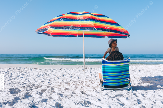 Black mother and son sitting on beach