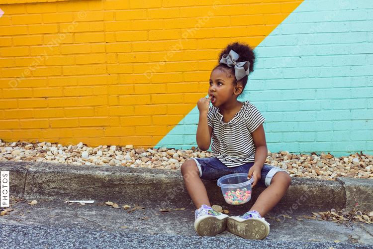 Girl sitting on sidewalk