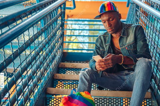 Young man in jean jacket and rainbow baseball cap