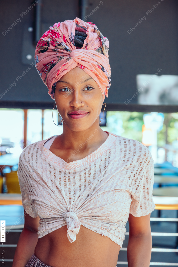 Portrait of woman wearing pink headwrap and tie front shirt