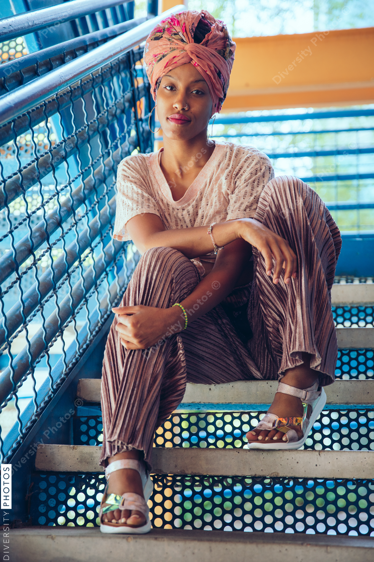 Portrait of woman wearing head wrap and sitting on stairs