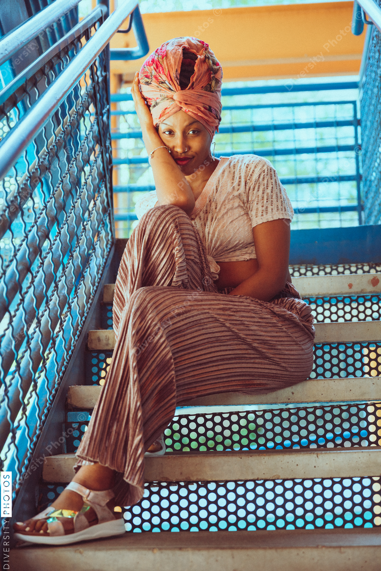Portrait of woman wearing head wrap and sitting on stairs
