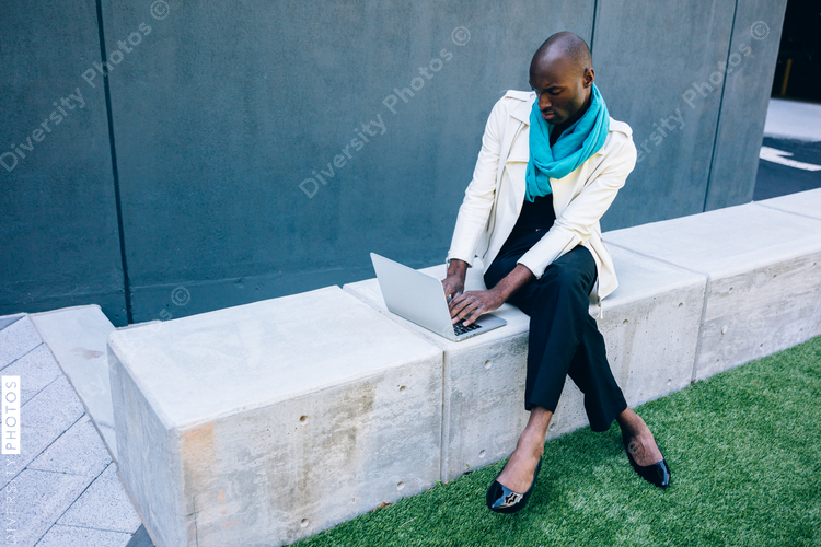 Man wearing high heels and working on laptop