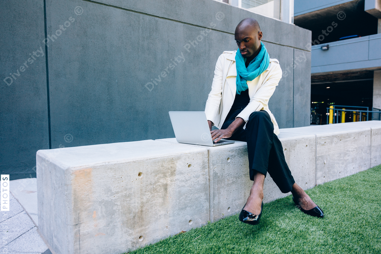 Man wearing high heels and working on laptop