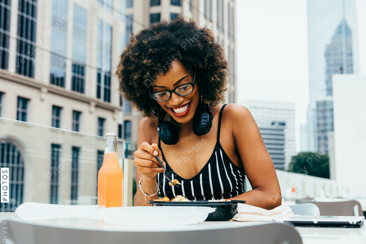Smiling woman eating lunch outdoors