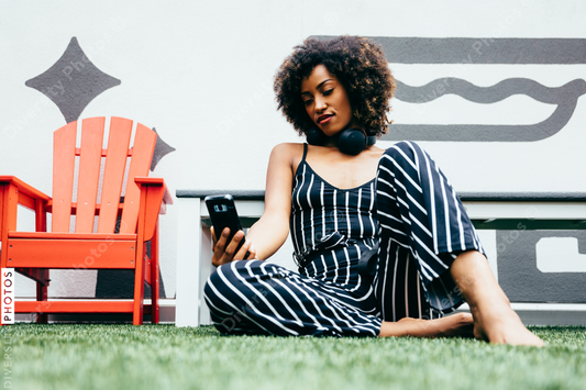 Barefoot woman looking at smartphone outdoors