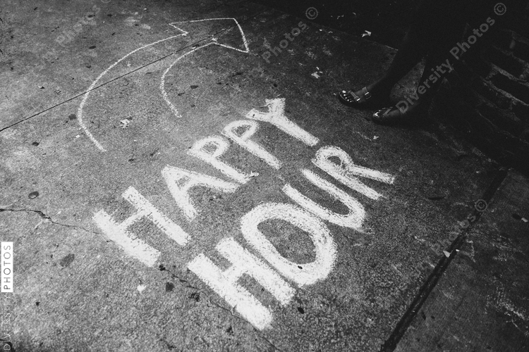 Happy hour written in chalk on sidewalk