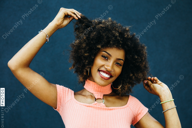 Smiling woman pulling on ends of her curly hair