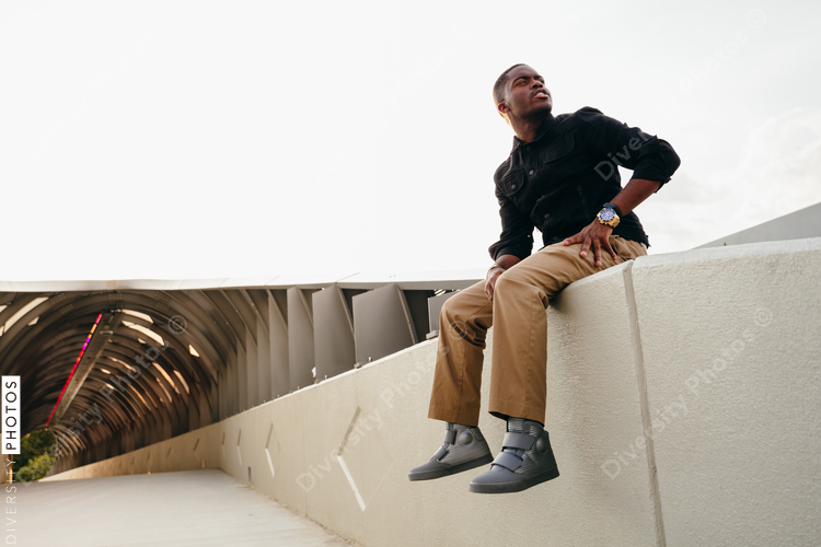 Low angle view of man sitting on wall looking aside