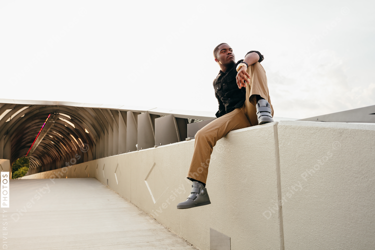 Low angle view of man sitting on wall