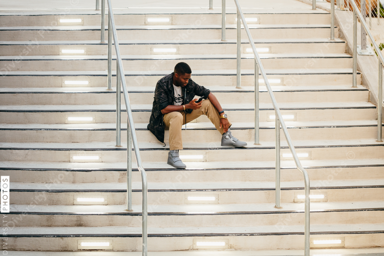 Man with mobile phone sitting on stairs