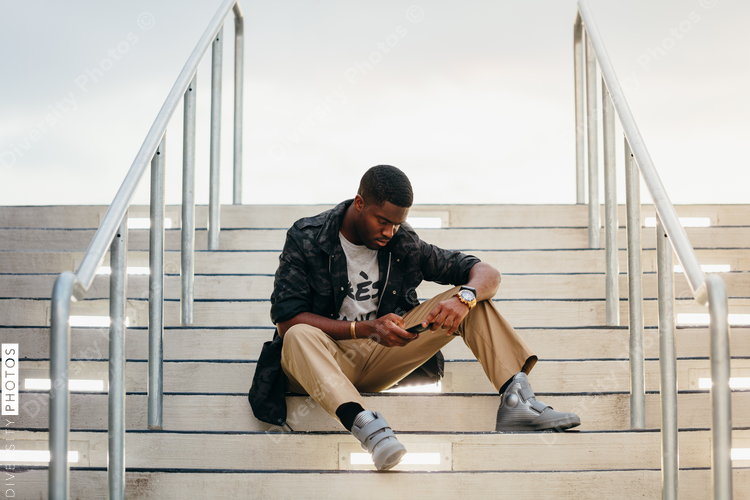 Man sitting on stairs with mobile phone