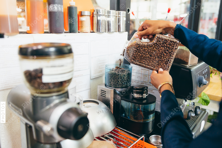 Barista grinding coffee beans at coffee shop