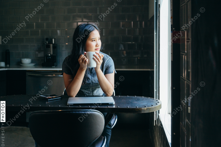Woman looking outside while having coffee 