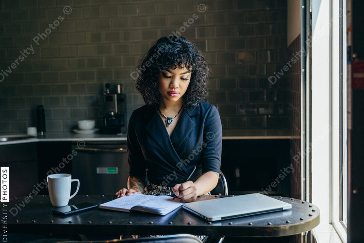 Woman writing in book at her desk