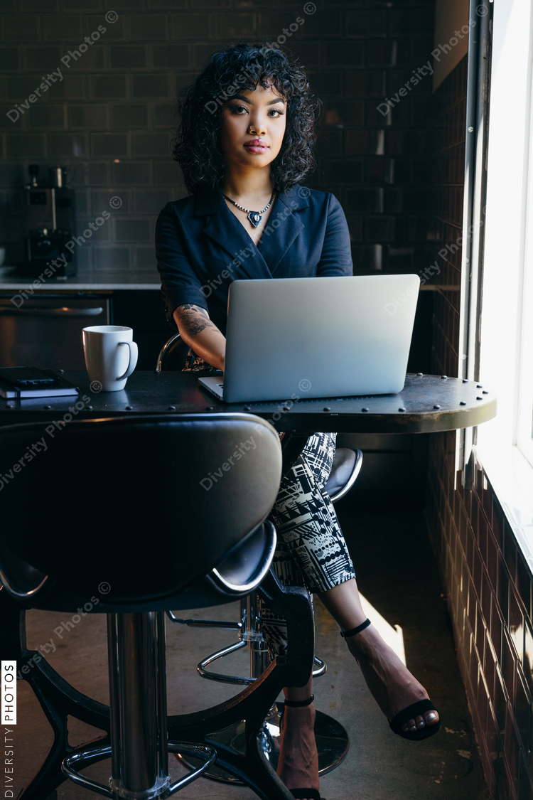 Portrait of young woman working in modern office cafeteria