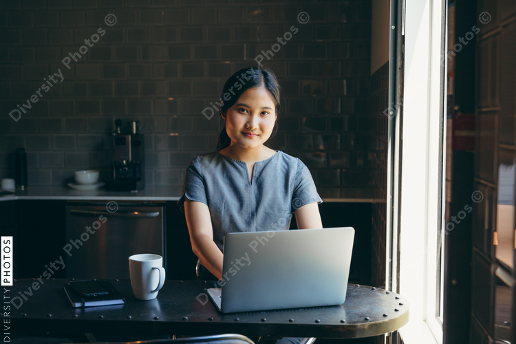 Close up view of young woman working in modern office cafeteria