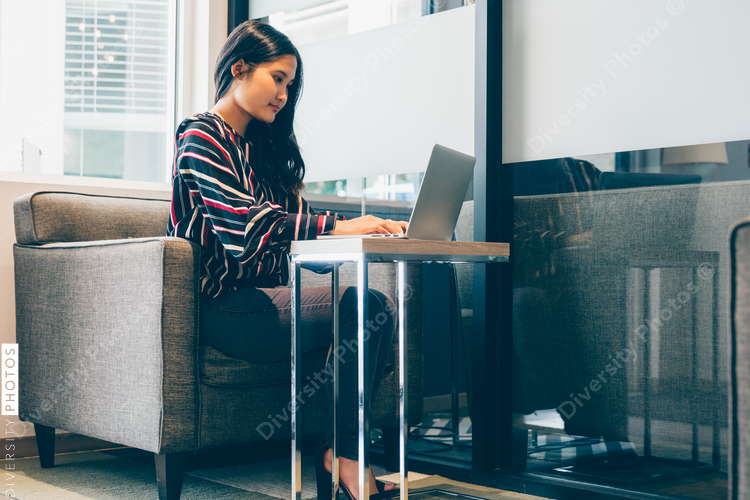 Direct view of businesswoman on couch with laptop