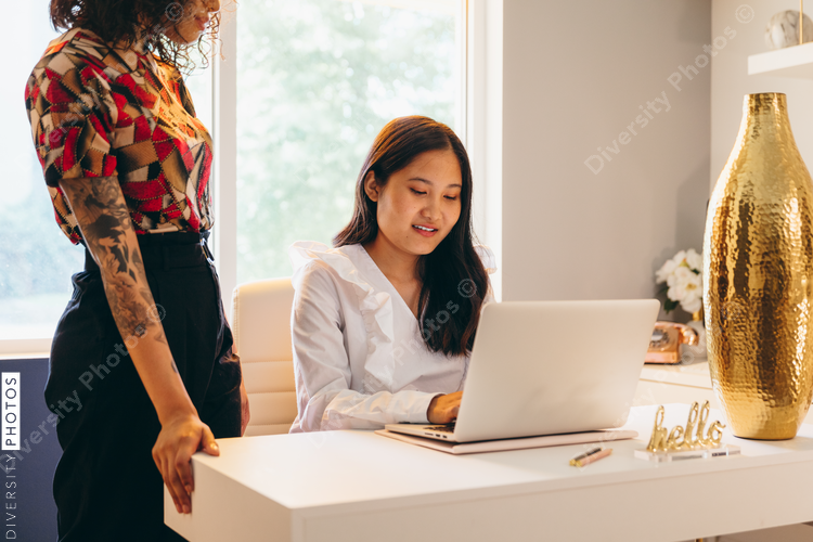 Close up view of two businesswomen working on laptop