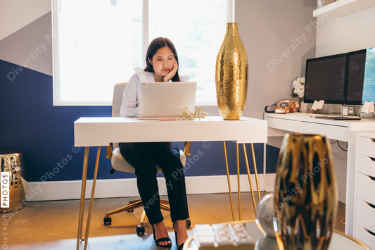 Young businesswoman sitting with palm rested on face