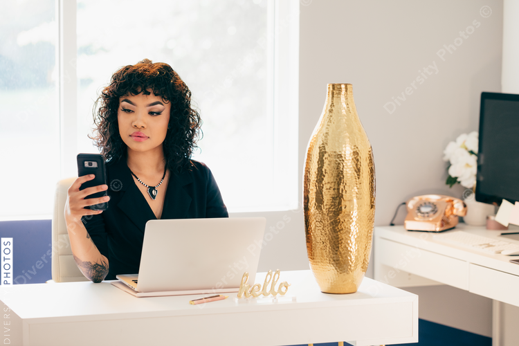 Young businesswoman with mobile phone in modern office space