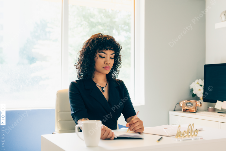 Direct view of left handed young businesswoman writing in diary