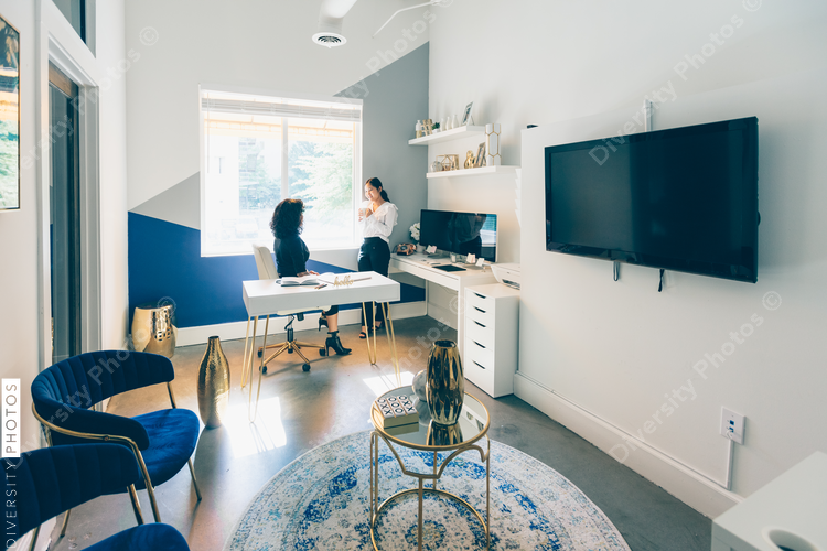 Panoramic view of two young businesswomen relaxing in office