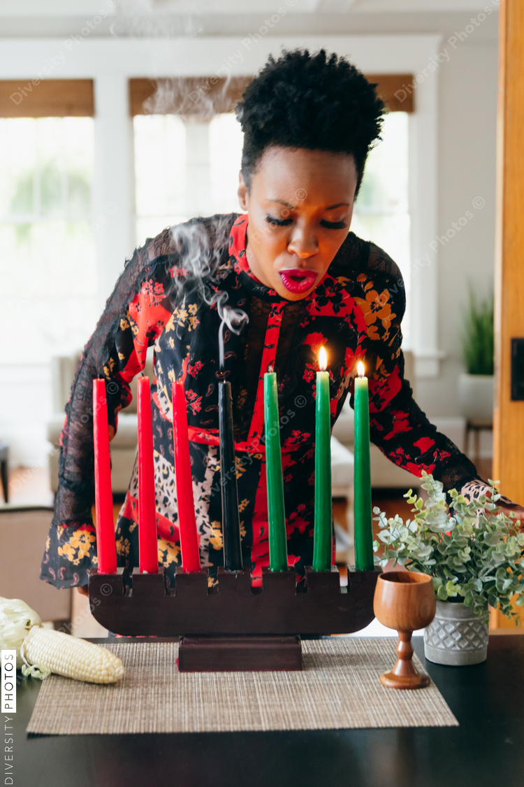 Woman blowing out Kwanzaa candles